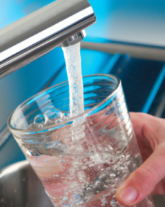 Image of glass being filled with water at a faucet.